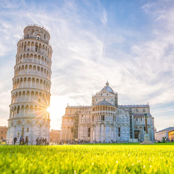 The Leaning Tower of Pisa rising above the emerald lawn of the Campo dei Miracoli at dawn
